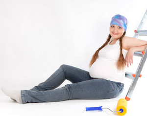 Беременная женщина сидит возле стремянки