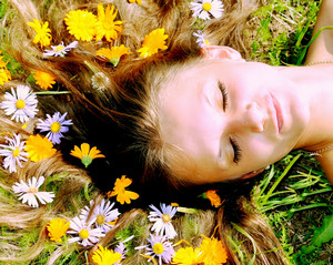 Девушка лежит на траве с цветами в волосах